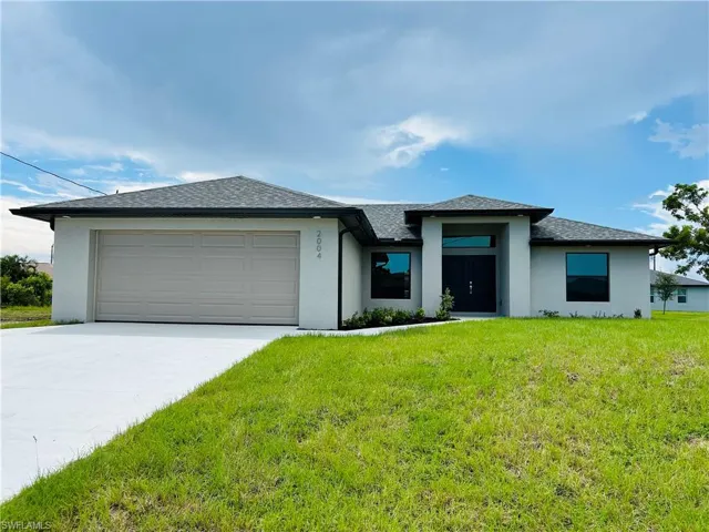 View of front of home featuring a front yard and a garage