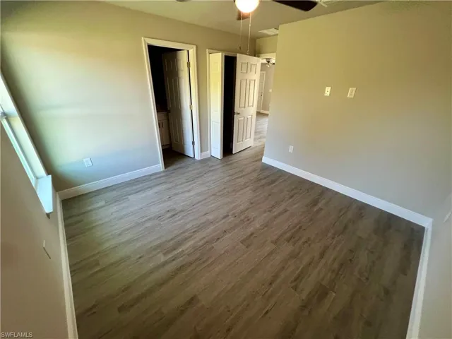 Unfurnished bedroom with ceiling fan and dark hardwood / wood-style floors