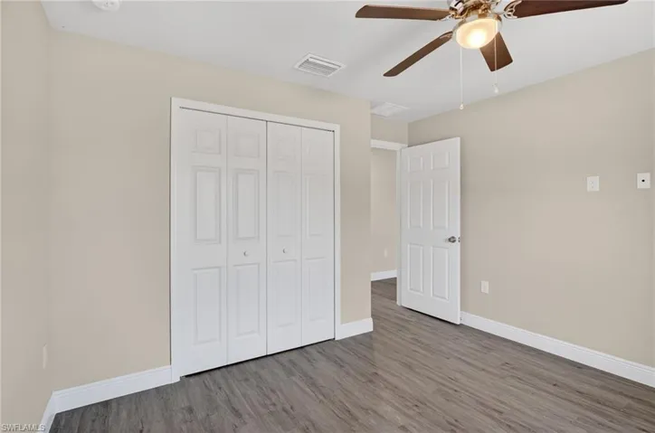 Unfurnished bedroom with wood finished floors, ceiling fan, and a closet