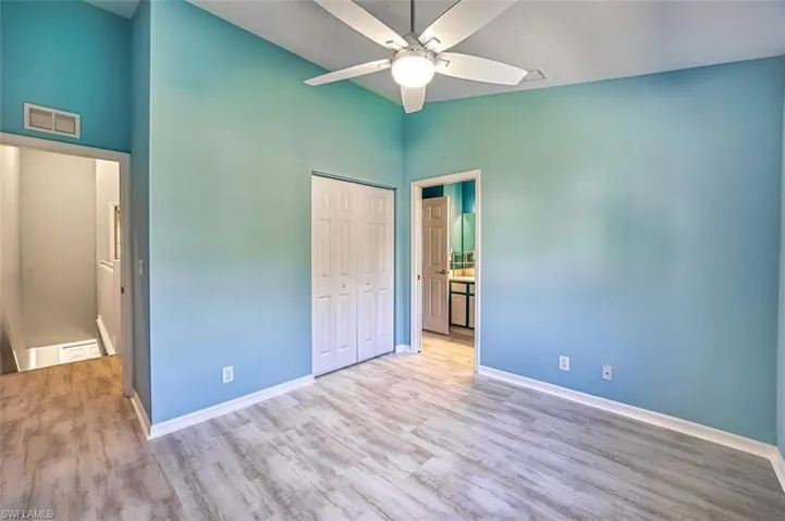 Full bathroom featuring bath / shower combo with glass door, toilet, vanity, ceiling fan, and wood-type flooring