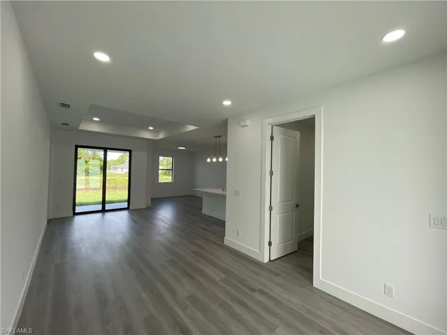 Spare room with recessed lighting, dark wood finished floors, and a raised ceiling
