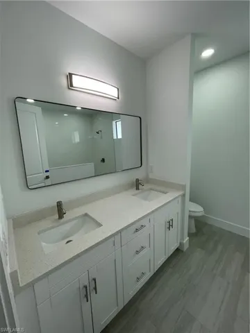 Bathroom with double vanity, a shower, and recessed lighting