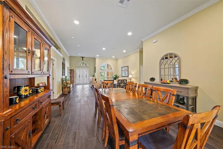 Dining area with visible vents, crown molding, baseboards, recessed lighting, and dark wood-type flooring