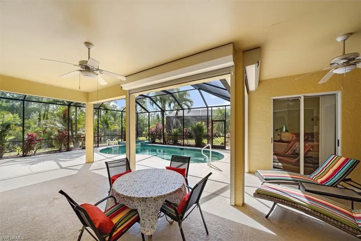 View of patio / terrace with glass enclosure, ceiling fan, and an outdoor pool
