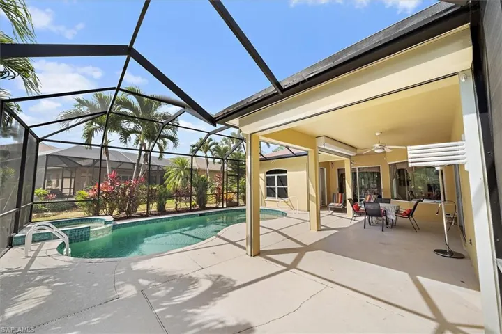 View of swimming pool featuring ceiling fan, a patio area, and a pool with connected hot tub