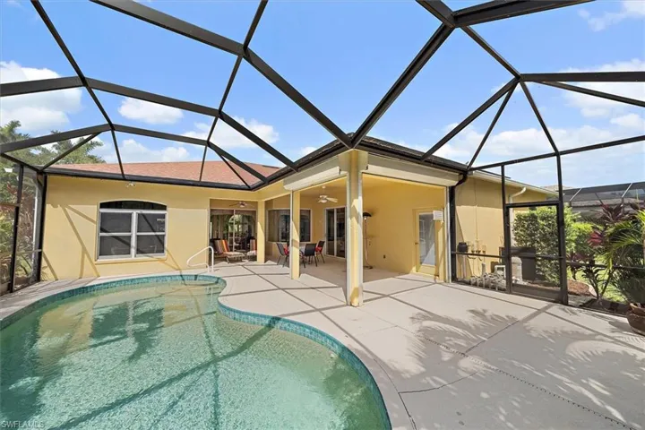 Back of house featuring a patio, ceiling fan, an outdoor pool, and stucco siding