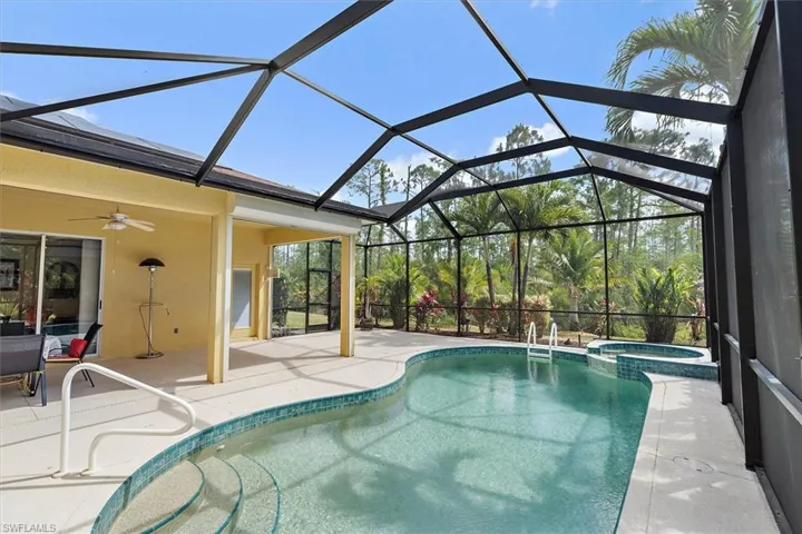View of swimming pool with a pool with connected hot tub, a ceiling fan, and a patio area