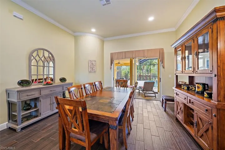 Dining area featuring ornamental molding, wood finish floors, recessed lighting, and visible vents