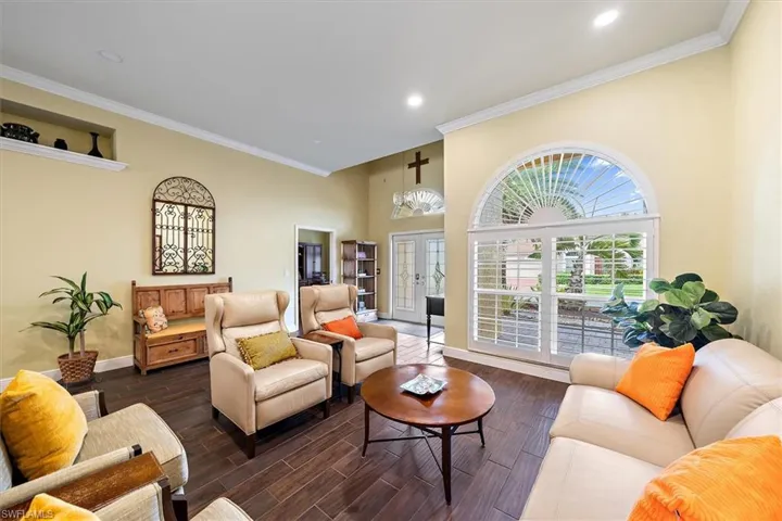 Living area featuring baseboards, ornamental molding, dark wood-style floors, and recessed lighting