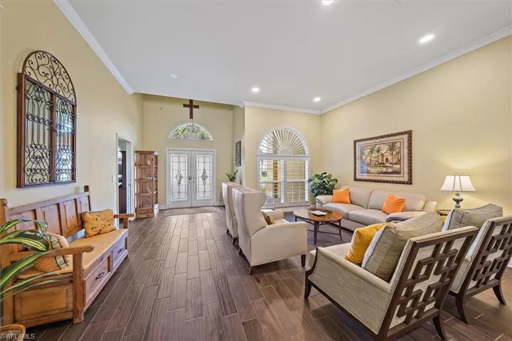 Living room with crown molding, recessed lighting, and dark wood-style floors