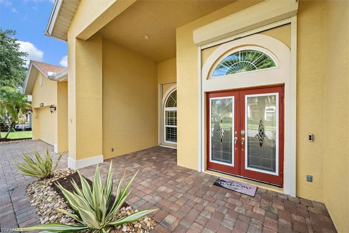 View of exterior entry with french doors, stucco siding, and an attached garage