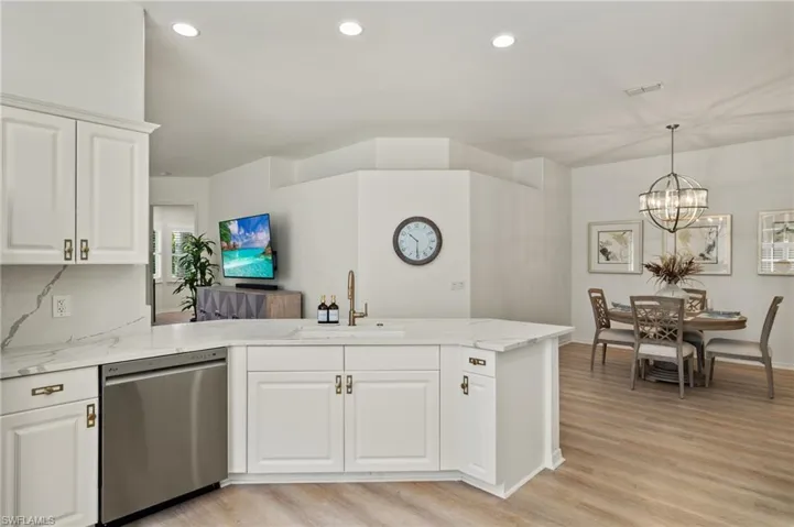 Kitchen featuring stainless steel appliances, LVP flooring, backsplash, and quartz counters