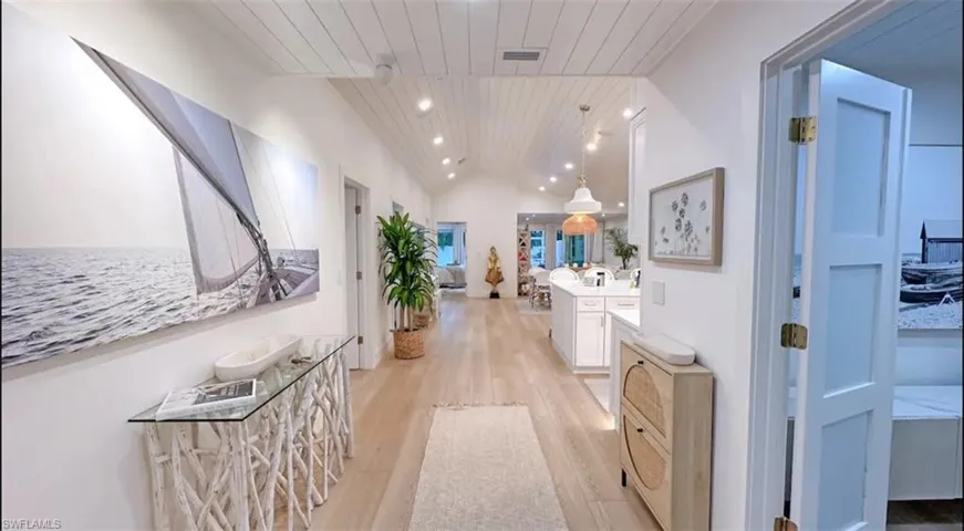 Hallway with a vaulted wooden ceiling, light wood-type flooring, and recessed lighting