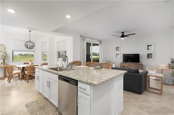 Kitchen with crown molding, a kitchen island with sink, dishwasher, and a sink