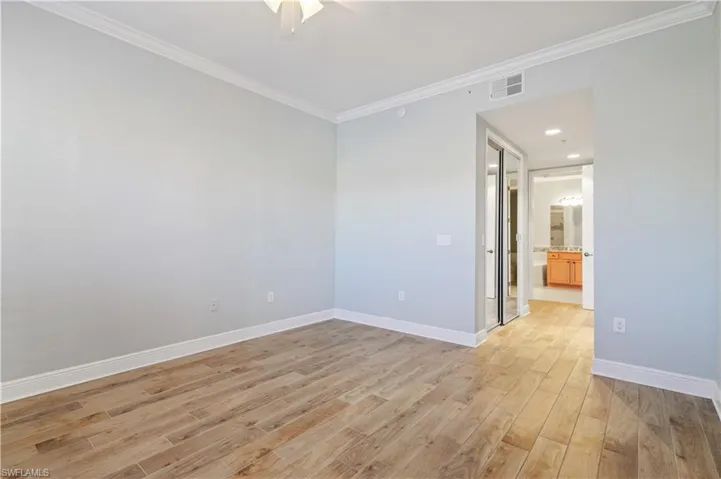 Primary room with a ceiling fan, baseboards, visible vents, light wood finished floors, and crown molding