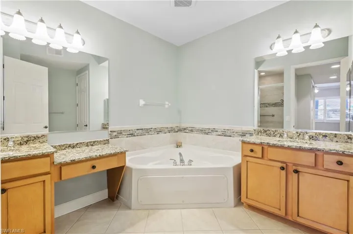 Primary Bathroom featuring tile patterned flooring, visible vents, a shower stall, and a garden tub