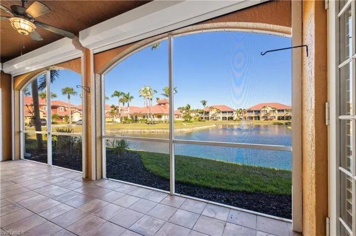 Sunroom with a water view, roll down shutters and a residential view