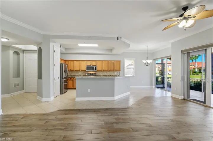 Kitchen featuring decorative backsplash, light wood-style flooring, appliances with stainless steel finishes, and visible vents