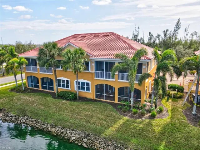 Rear view of property with a water view and a lawn