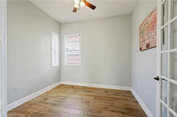 Empty room with baseboards, a ceiling fan, and light wood finished floors