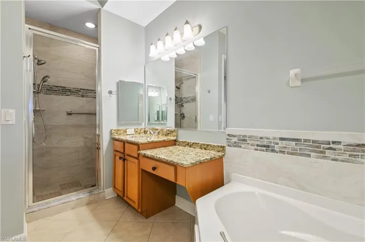 Primary Bath Full bath featuring vanity, a bath, and a shower stall