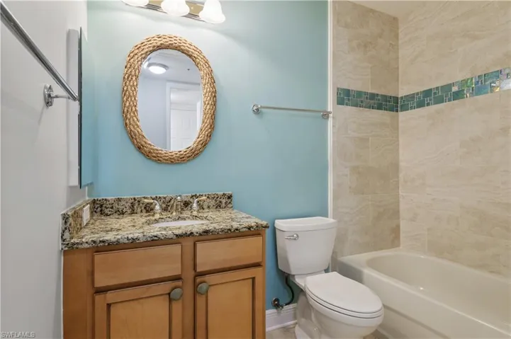 Full bath featuring shower / bath combination, baseboards, toilet, and vanity