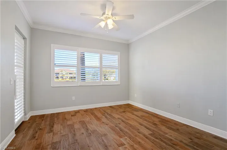 Primary Bedroom featuring baseboards, crown molding, ceiling fan, and wood finished floors