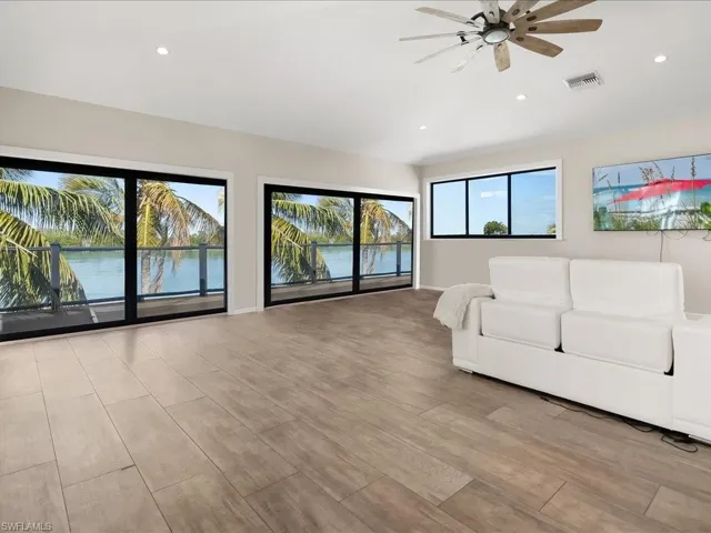 Living area with a ceiling fan, light wood-style flooring, recessed lighting, and a water view