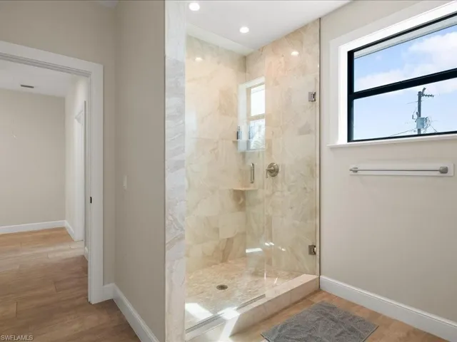 Bathroom with a shower stall, light wood finished floors, and recessed lighting