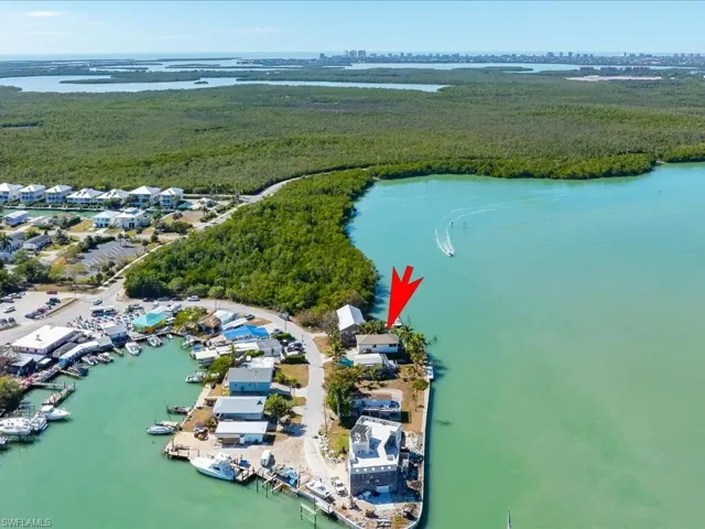 View of property location with a large body of water and a heavily wooded area