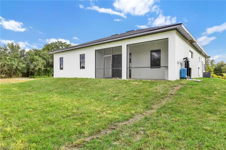 Rear view of property featuring stucco siding and a yard