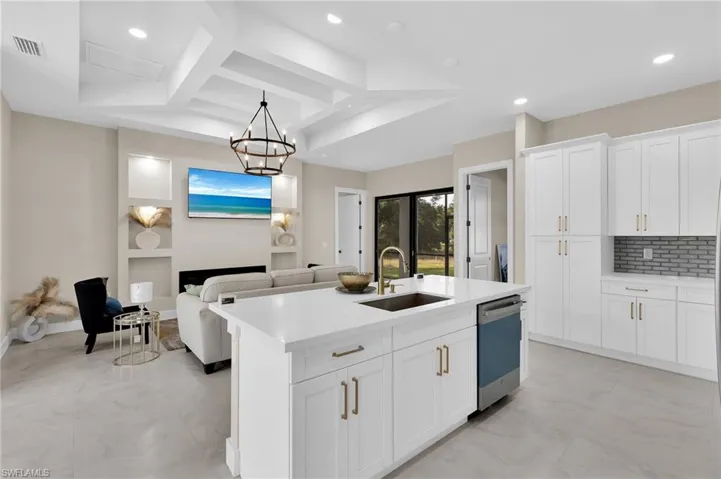 Kitchen featuring coffered ceiling, white cabinets, beam ceiling, open floor plan, and pendant lighting