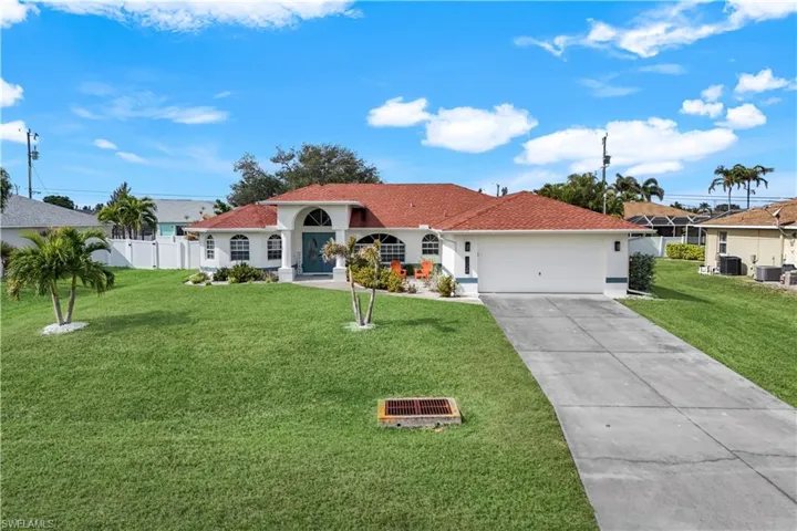 View of front of house featuring a garage, central AC, and a front yard