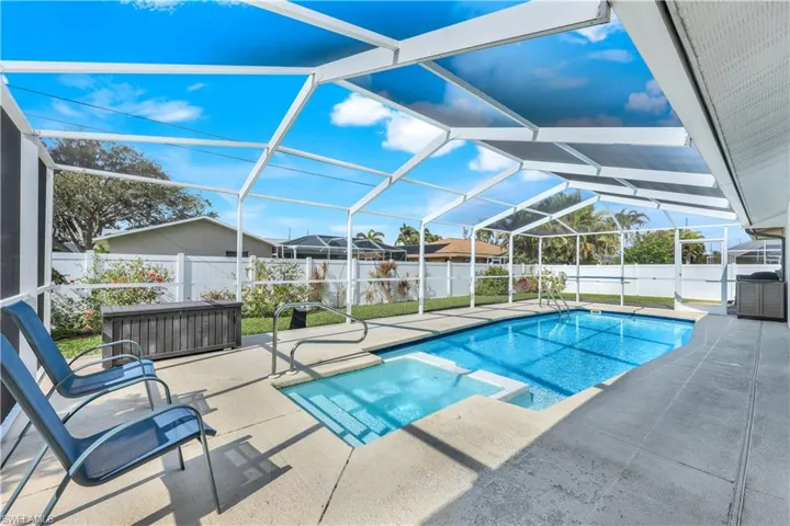 View of swimming pool featuring a patio and glass enclosure