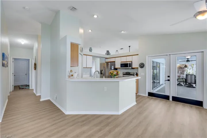Kitchen featuring sink, vaulted ceiling, stainless steel appliances, and ceiling fan