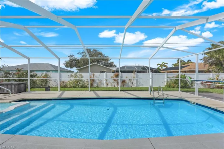 View of pool with glass enclosure and a patio area