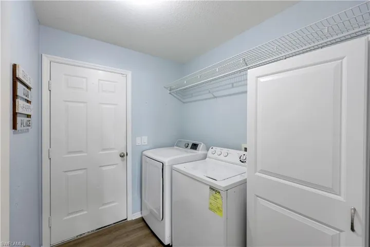 Clothes washing area with separate washer and dryer, dark hardwood / wood-style floors, and a textured ceiling