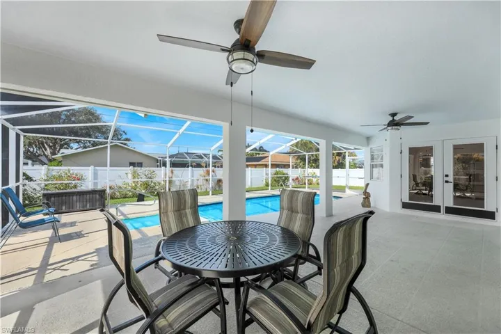 View of patio / terrace with a fenced in pool, glass enclosure, ceiling fan, and french doors