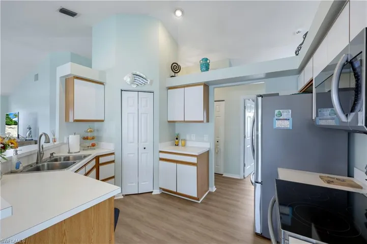 Kitchen featuring white cabinetry, stainless steel appliances, sink, and light hardwood / wood-style flooring