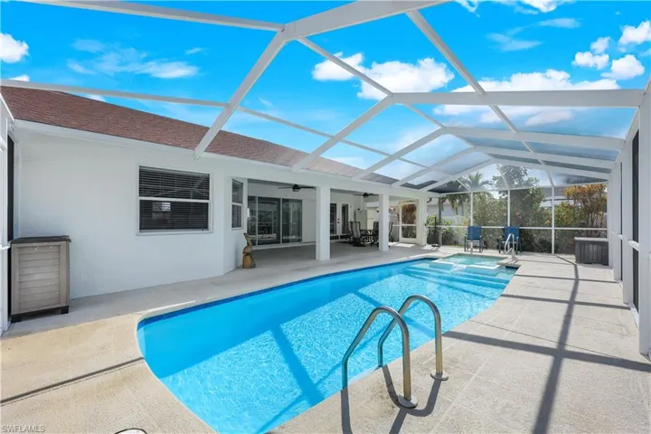 View of pool with a lanai, ceiling fan, and a patio area