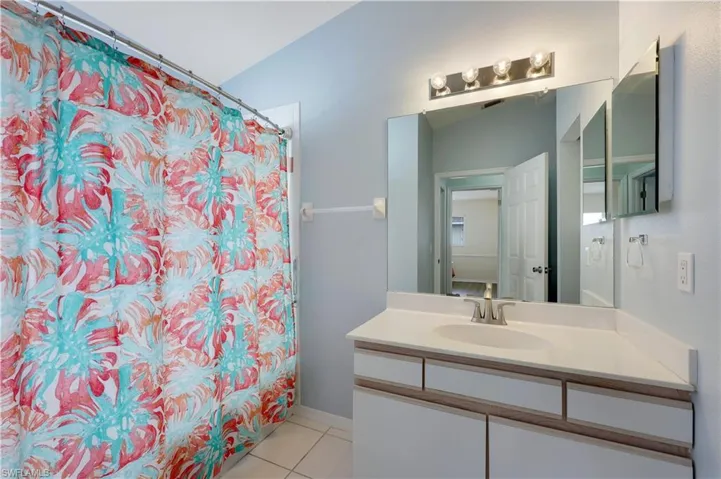 Bathroom featuring tile patterned flooring, vanity, and a shower with curtain