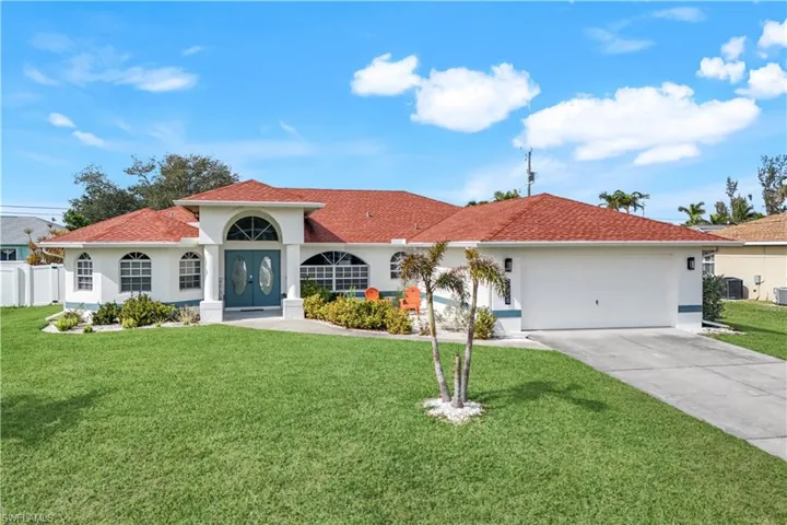 Mediterranean / spanish-style home featuring cooling unit, a garage, and a front yard