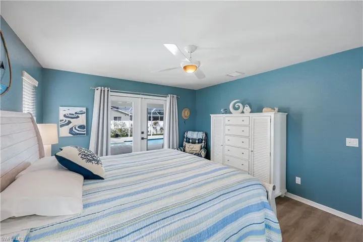 Bedroom with ceiling fan, access to exterior, dark hardwood / wood-style flooring, and french doors