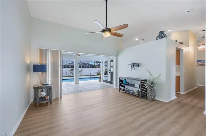 Living room featuring high vaulted ceiling, light hardwood / wood-style floors, and ceiling fan