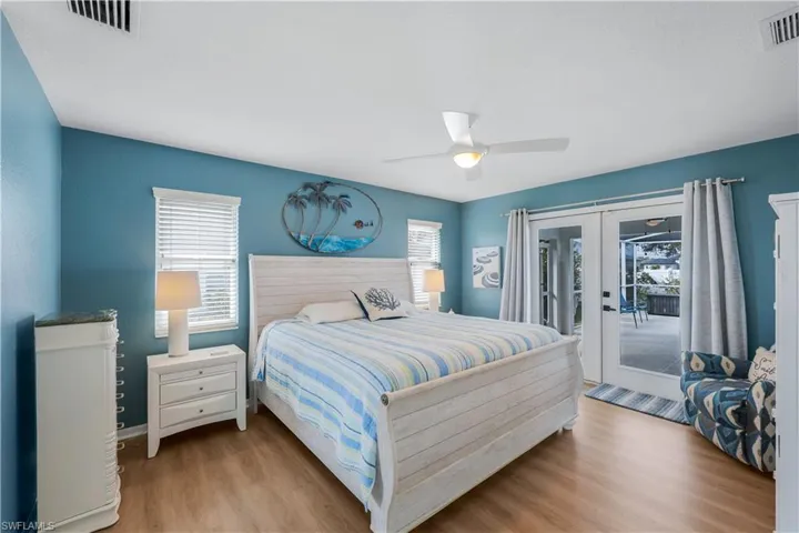 Bedroom with multiple windows, access to exterior, light hardwood / wood-style flooring, and french doors