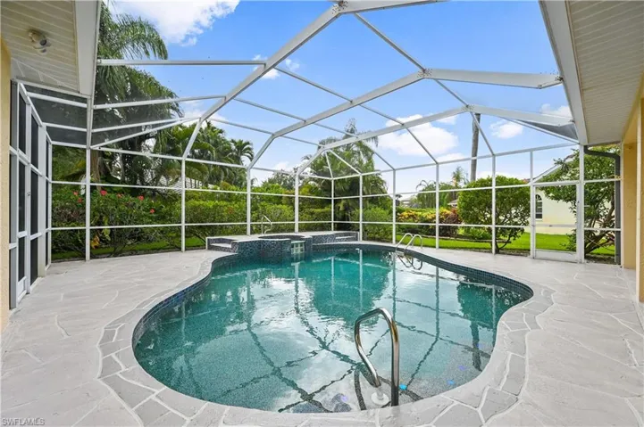 View of pool with a patio area, a sunroom, ceiling fan, a pool with connected hot tub, and glass enclosure