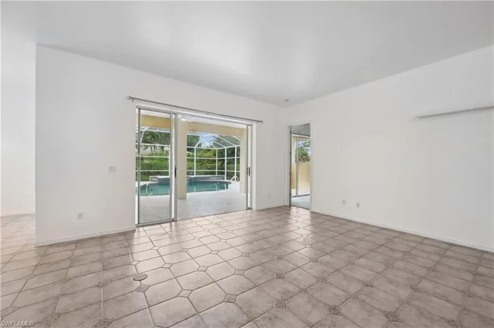 Unfurnished room featuring a sunroom and baseboards