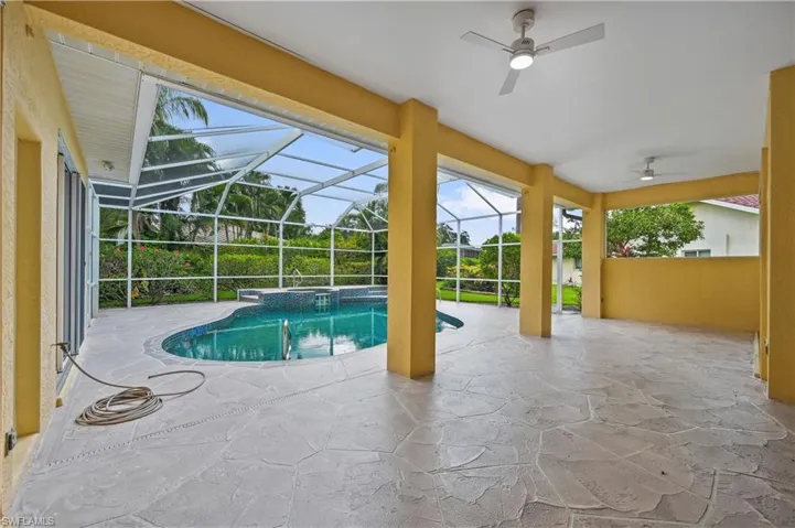 View of pool with a patio area, a sunroom, ceiling fan, a pool with connected hot tub, and glass enclosure