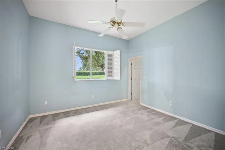 Carpeted empty room with baseboards and a ceiling fan