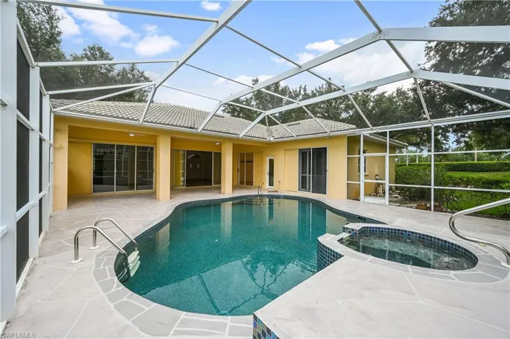View of pool featuring a sunroom, a patio, and a pool with connected hot tub
